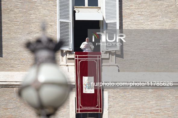 Pope Francis addresses the crowd from the window of the apostolic palace overlooking St. Peter's Square during the Angelus prayer in The Vat...