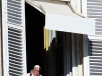 Pope Francis addresses the crowd from the window of the apostolic palace overlooking St. Peter's Square during the Angelus prayer in The Vat...