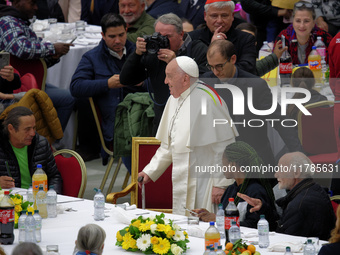 Pope Francis sits to share a lunch with people on the World Day of the Poor at the Paul VI audience hall in The Vatican, on November 17, 202...