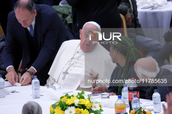 Pope Francis sits to share a lunch with people on the World Day of the Poor at the Paul VI audience hall in The Vatican, on November 17, 202...