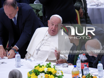 Pope Francis sits to share a lunch with people on the World Day of the Poor at the Paul VI audience hall in The Vatican, on November 17, 202...