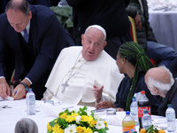 Pope Francis sits to share a lunch with people on the World Day of the Poor at the Paul VI audience hall in The Vatican, on November 17, 202...