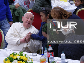 Pope Francis sits to share a lunch with people on the World Day of the Poor at the Paul VI audience hall in The Vatican, on November 17, 202...