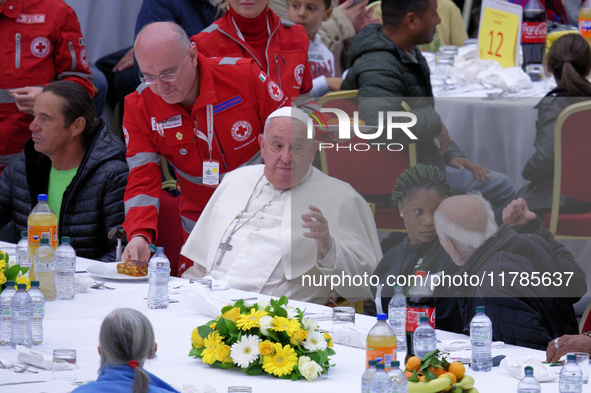 Pope Francis sits to share a lunch with people on the World Day of the Poor at the Paul VI audience hall in The Vatican, on November 17, 202...