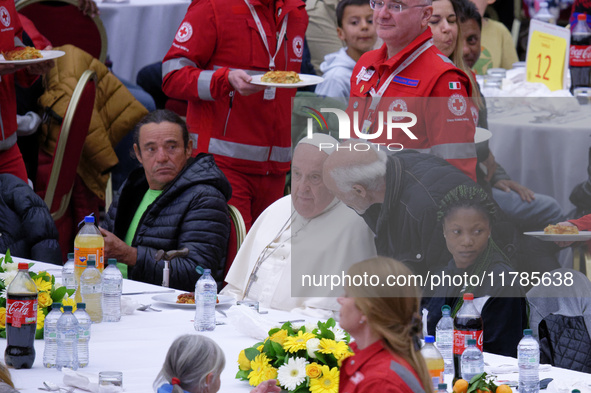 Pope Francis sits to share a lunch with people on the World Day of the Poor at the Paul VI audience hall in The Vatican, on November 17, 202...