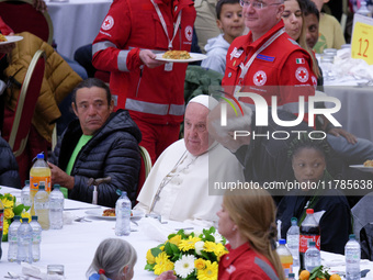 Pope Francis sits to share a lunch with people on the World Day of the Poor at the Paul VI audience hall in The Vatican, on November 17, 202...