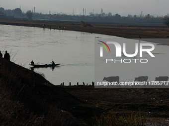 Kashmiri men walk with cattle (cows) on a cold day in Sopore, Jammu and Kashmir, India, on November 17, 2024. (