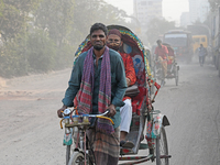 People navigate a dusty road in Dhaka, Bangladesh, on November 17, 2024. The city has ranked first on the list of cities with the worst air...