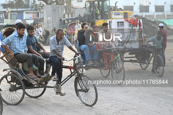 People navigate a dusty road in Dhaka, Bangladesh, on November 17, 2024. The city has ranked first on the list of cities with the worst air...