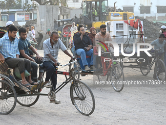 People navigate a dusty road in Dhaka, Bangladesh, on November 17, 2024. The city has ranked first on the list of cities with the worst air...