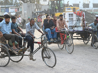 People navigate a dusty road in Dhaka, Bangladesh, on November 17, 2024. The city has ranked first on the list of cities with the worst air...