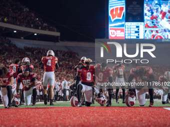 Wisconsin Badgers safety Austin Brown #9 and Wisconsin Badgers wide receiver Bryson Green #9 take a knee prior to kickoff in Madison, Wiscon...