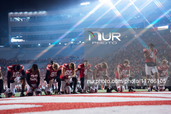 The Wisconsin Badgers take a knee prior to kickoff in Madison, Wisconsin, on November 16, 2024, during the game between the Wisconsin Badger...