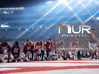 The Wisconsin Badgers take a knee prior to kickoff in Madison, Wisconsin, on November 16, 2024, during the game between the Wisconsin Badger...