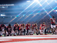 The Wisconsin Badgers take a knee prior to kickoff in Madison, Wisconsin, on November 16, 2024, during the game between the Wisconsin Badger...