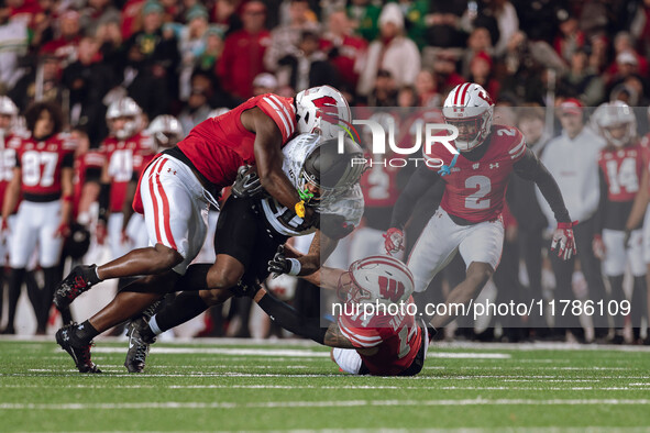 Oregon running back Jordan James #20 is taken down by Wisconsin Badgers outside linebacker Leon Lowery Jr. #8 and Wisconsin Badgers safety P...