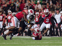 Oregon running back Jordan James #20 is taken down by Wisconsin Badgers outside linebacker Leon Lowery Jr. #8 and Wisconsin Badgers safety P...