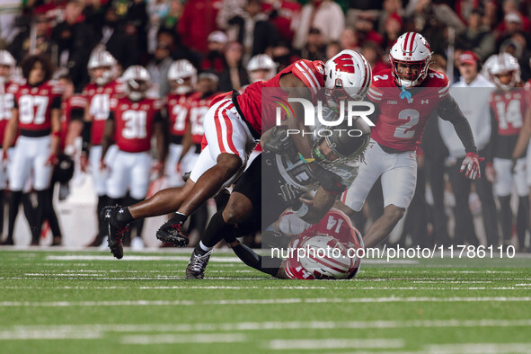 Oregon running back Jordan James #20 is taken down by Wisconsin Badgers outside linebacker Leon Lowery Jr. #8 and Wisconsin Badgers safety P...