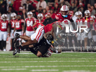 Oregon running back Jordan James #20 is taken down by Wisconsin Badgers outside linebacker Leon Lowery Jr. #8 and Wisconsin Badgers safety P...