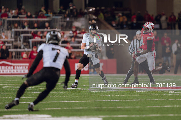 Oregon quarterback Dillon Gabriel #8 looks downfield to Oregon wide receiver Evan Stewart #7 while being pursued by Wisconsin Badgers outsid...