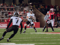 Oregon quarterback Dillon Gabriel #8 looks downfield to Oregon wide receiver Evan Stewart #7 while being pursued by Wisconsin Badgers outsid...