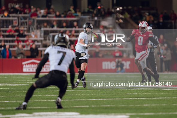 Oregon quarterback Dillon Gabriel #8 looks downfield to Oregon wide receiver Evan Stewart #7 while being pursued by Wisconsin Badgers outsid...