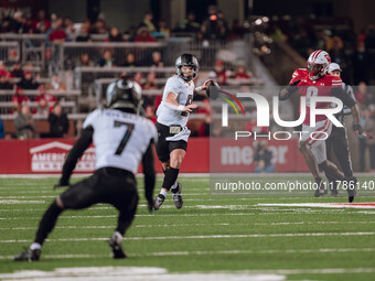 Oregon quarterback Dillon Gabriel #8 looks downfield to Oregon wide receiver Evan Stewart #7 while being pursued by Wisconsin Badgers outsid...