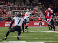 Oregon quarterback Dillon Gabriel #8 looks downfield to Oregon wide receiver Evan Stewart #7 while being pursued by Wisconsin Badgers outsid...