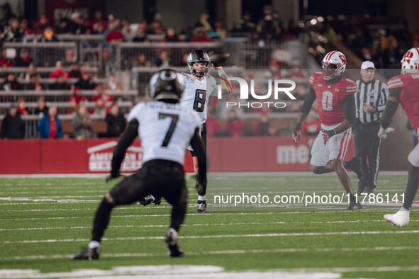 Oregon quarterback Dillon Gabriel #8 looks downfield to Oregon wide receiver Evan Stewart #7 while being pursued by Wisconsin Badgers outsid...