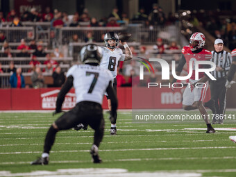 Oregon quarterback Dillon Gabriel #8 looks downfield to Oregon wide receiver Evan Stewart #7 while being pursued by Wisconsin Badgers outsid...