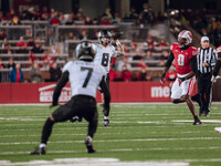 Oregon quarterback Dillon Gabriel #8 looks downfield to Oregon wide receiver Evan Stewart #7 while being pursued by Wisconsin Badgers outsid...