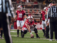 Wisconsin Badgers quarterback Braedyn Locke #18 and Wisconsin Badgers offensive lineman Jake Renfro #57 read the Oregon defense before the s...