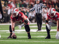 Wisconsin Badgers offensive lineman Jake Renfro #57 and Wisconsin Badgers offensive lineman Joe Brunner #56 get ready before the snap agains...