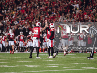 Wisconsin Badgers punter Gavin Meyers #28, Wisconsin Badgers safety Cayson Pfeiffer #99, and Wisconsin Badgers kicker Nathanial Vakos #90 ce...