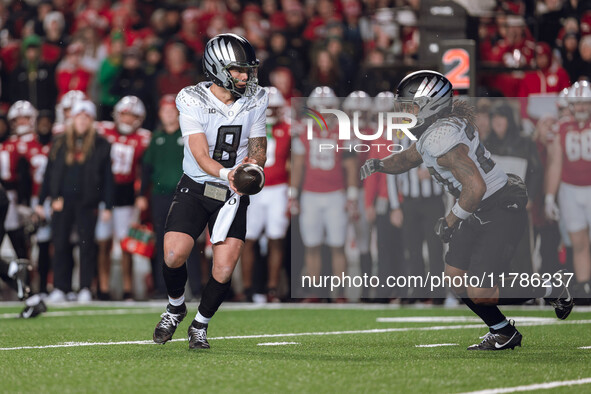 Oregon quarterback Dillon Gabriel #8 hands the ball off to Oregon running back Jordan James #20 against the Wisconsin Badgers at Camp Randal...