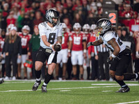 Oregon quarterback Dillon Gabriel #8 hands the ball off to Oregon running back Jordan James #20 against the Wisconsin Badgers at Camp Randal...