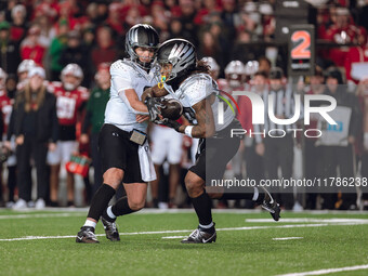 Oregon quarterback Dillon Gabriel #8 hands the ball off to Oregon running back Jordan James #20 against the Wisconsin Badgers at Camp Randal...