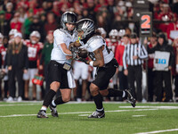 Oregon quarterback Dillon Gabriel #8 hands the ball off to Oregon running back Jordan James #20 against the Wisconsin Badgers at Camp Randal...