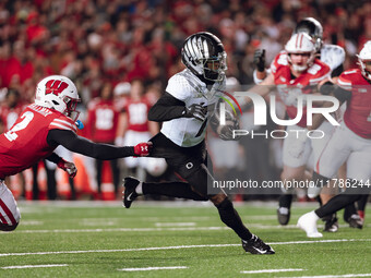 Oregon wide receiver Evan Stewart #7 escapes the clutches of Wisconsin Badgers cornerback Ricardo Hallman #2 at Camp Randall Stadium in Madi...