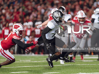 Oregon wide receiver Evan Stewart #7 escapes the clutches of Wisconsin Badgers cornerback Ricardo Hallman #2 at Camp Randall Stadium in Madi...