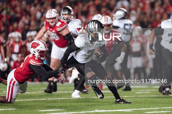 Oregon wide receiver Evan Stewart #7 escapes the clutches of Wisconsin Badgers cornerback Ricardo Hallman #2 at Camp Randall Stadium in Madi...