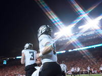 Oregon quarterback Dillon Gabriel #8 returns to the sideline after a touchdown against the Wisconsin Badgers at Camp Randall Stadium in Madi...