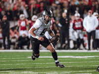 Oregon quarterback Dillon Gabriel #8 scrambles against the Wisconsin Badgers at Camp Randall Stadium in Madison, Wisconsin, on November 16,...