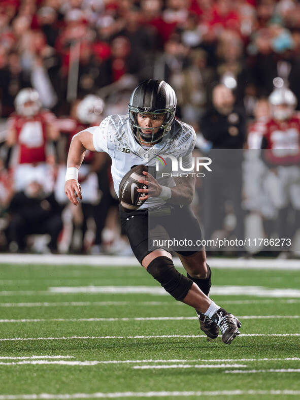 Oregon quarterback Dillon Gabriel #8 scrambles against the Wisconsin Badgers at Camp Randall Stadium in Madison, Wisconsin, on November 16,...