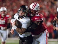 Oregon quarterback Dillon Gabriel #8 is tackled by Wisconsin Badgers defensive lineman Curt Neal #92 at Camp Randall Stadium in Madison, Wis...