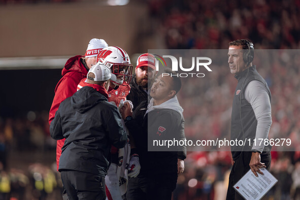 Wisconsin Badgers safety Hunter Wohler #24 receives attention from the Wisconsin Badgers medical staff as Wisconsin Badgers Head Coach Luke...