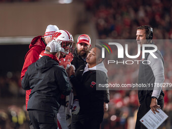 Wisconsin Badgers safety Hunter Wohler #24 receives attention from the Wisconsin Badgers medical staff as Wisconsin Badgers Head Coach Luke...