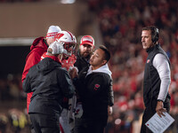 Wisconsin Badgers safety Hunter Wohler #24 receives attention from the Wisconsin Badgers medical staff as Wisconsin Badgers Head Coach Luke...