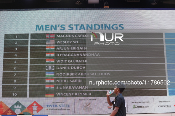 A man walks past a display board that shows the names of men's chess players after finishing the match on the last day of the 6th Tata Steel...