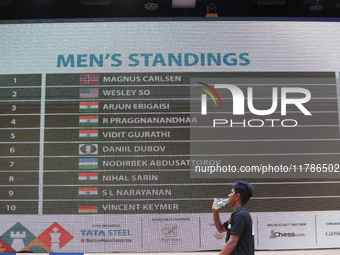 A man walks past a display board that shows the names of men's chess players after finishing the match on the last day of the 6th Tata Steel...